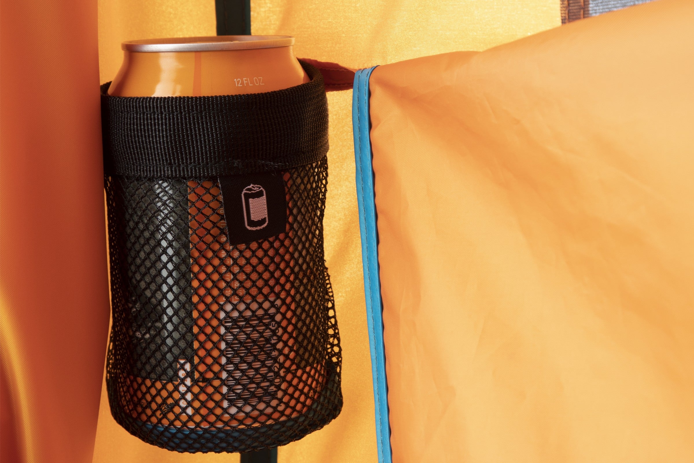 An aluminum can sits in a black mesh holder attached to the Heliopolis™ Privacy Shelter & Shower Tent by NEMO Equipment, offering convenient organization inside your portable privacy shelter.